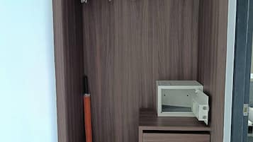 A wardrobe with a hanging rod, a shoe rack, and a small table with a printer.