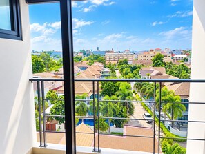 A residential area with a view from a balcony, featuring houses, greenery, and a clear sky. - Starlight Hotel Pattaya  Le Vernissage (Pattaya)