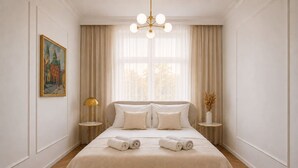 Ein Hotelzimmer mit einem großen Bett, zwei Nachttischen, einer Kandelaber und einem Gemälde an der Wand.