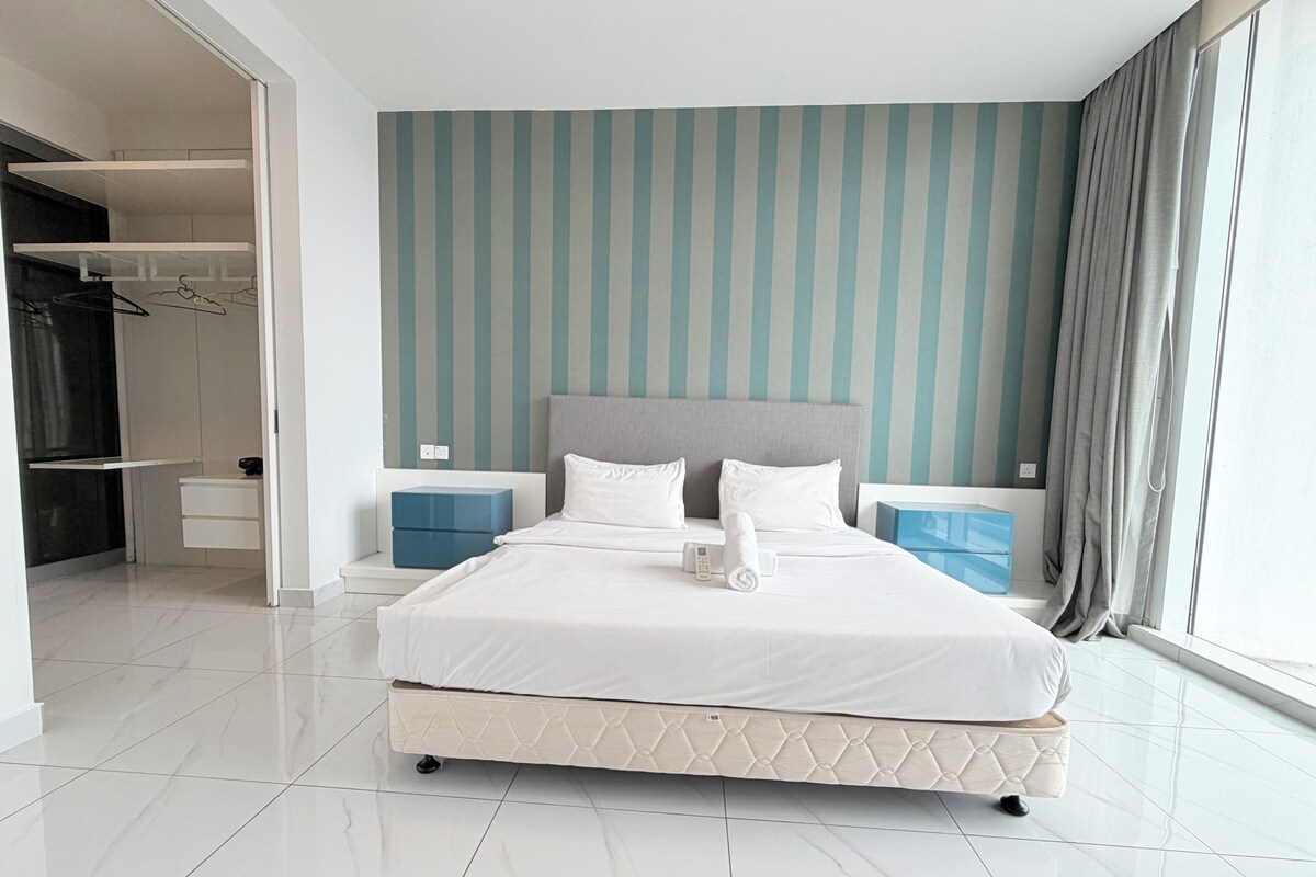 Une chambre d’hôtel moderne, dotée d’un grand lit, d’une armoire, d’une table de chevet et offrant une vue sur l’extérieur.