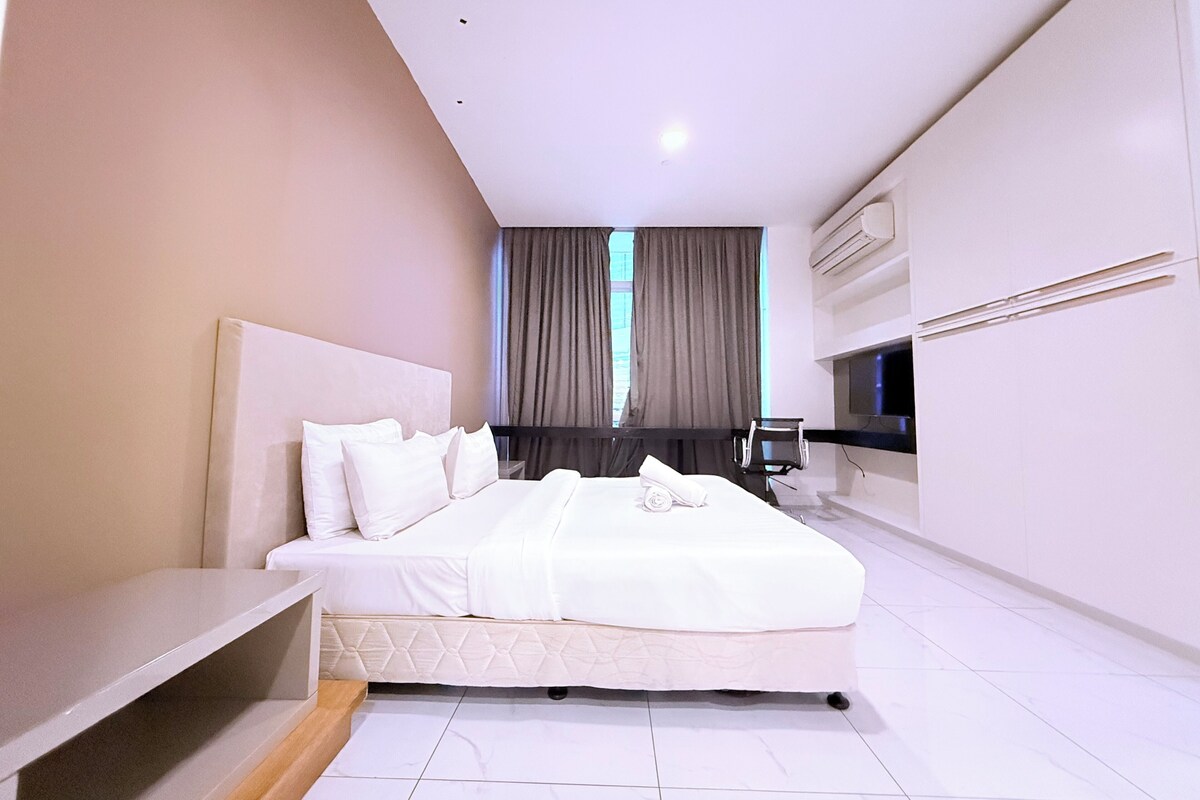 Une chambre d’hôtel moderne équipée d’un grand lit, d’une télévision, d’un bureau et d’une chaise.