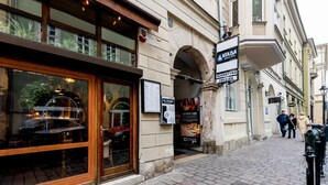 En gata med en restaurang som heter ”Kolba” och en skylt för ”Cosmetyka Fryzjer”.