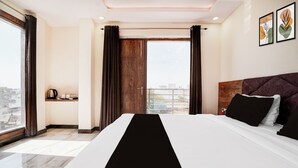 A hotel room with a large bed, a coffee station, and a city view. - Super Townhouse Taj Mahal East Gate (Agra)