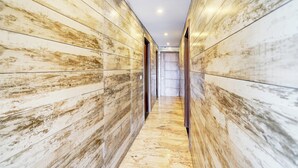 A hallway with a marble floor and wooden panel walls. - Super Townhouse Taj Mahal East Gate (Agra)