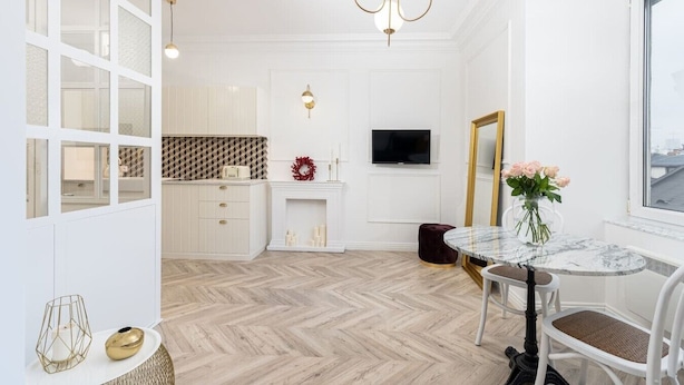 Un interior moderno con piso de madera en serbia, un comedor con mesa de mármol y un espejo grande.