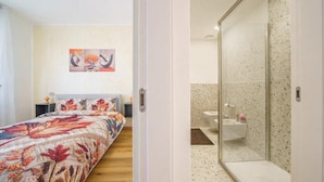 Een slaapkamer met een bed, een nachtkastje en een schilderij aan de muur.
