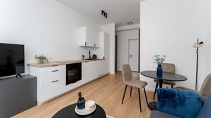 En moderne lejlighed med køkken, spiseområde og opholdsstue.
