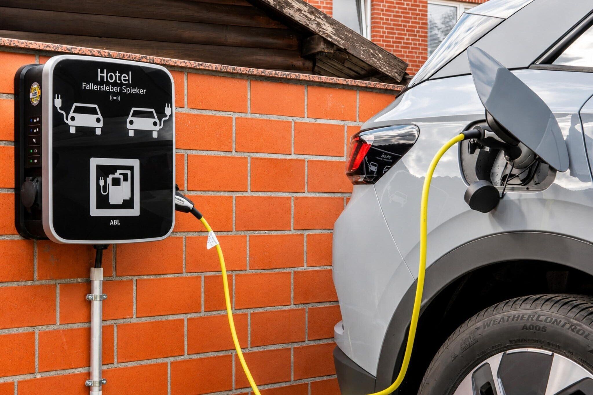 Eine Ladestation für Elektroautos, beschriftet mit 'Hotel', mit einem angeschlossenen Auto.