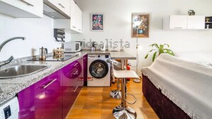 Cocina compacta con lavadora, fregadero y microondas.