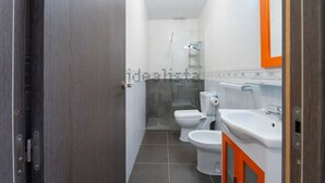 Un baño con ducha, inodoro y lavamanos.