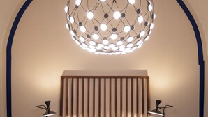 Ein Schlafzimmer mit einem Bett, Nachttischen, einer außergewöhnlichen, kugelförmigen Leuchte und einem Holzkopfende.