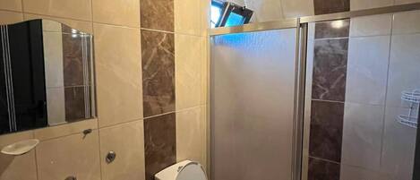 A bathroom with a sink, toilet, and shower.