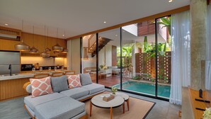 Un espacio moderno para relajarse con sofá, mesa de centro y vista a la piscina.