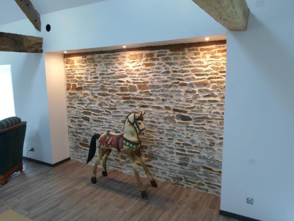 A room with a stone wall, a wooden beam ceiling, and a horse sculpture.