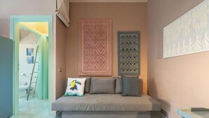 Ein Zimmer mit einer Couch, einer Himmelsleiter, einem Wandbehang mit Muster und einer dekorativen Wandverkleidung.