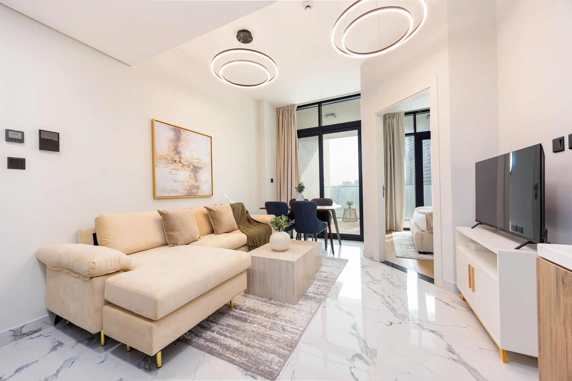 A modern living room with a sofa, coffee table, and a flat-screen TV.