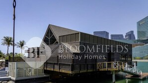 Une maison de vacances moderne dotée d’une grande terrasse, d’un espace extérieur couvert et offrant une vue sur le paysage urbain.