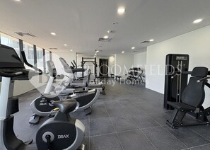 Ein Fitnessstudio mit Laufbändern, Crosstrainern und Gewichten.