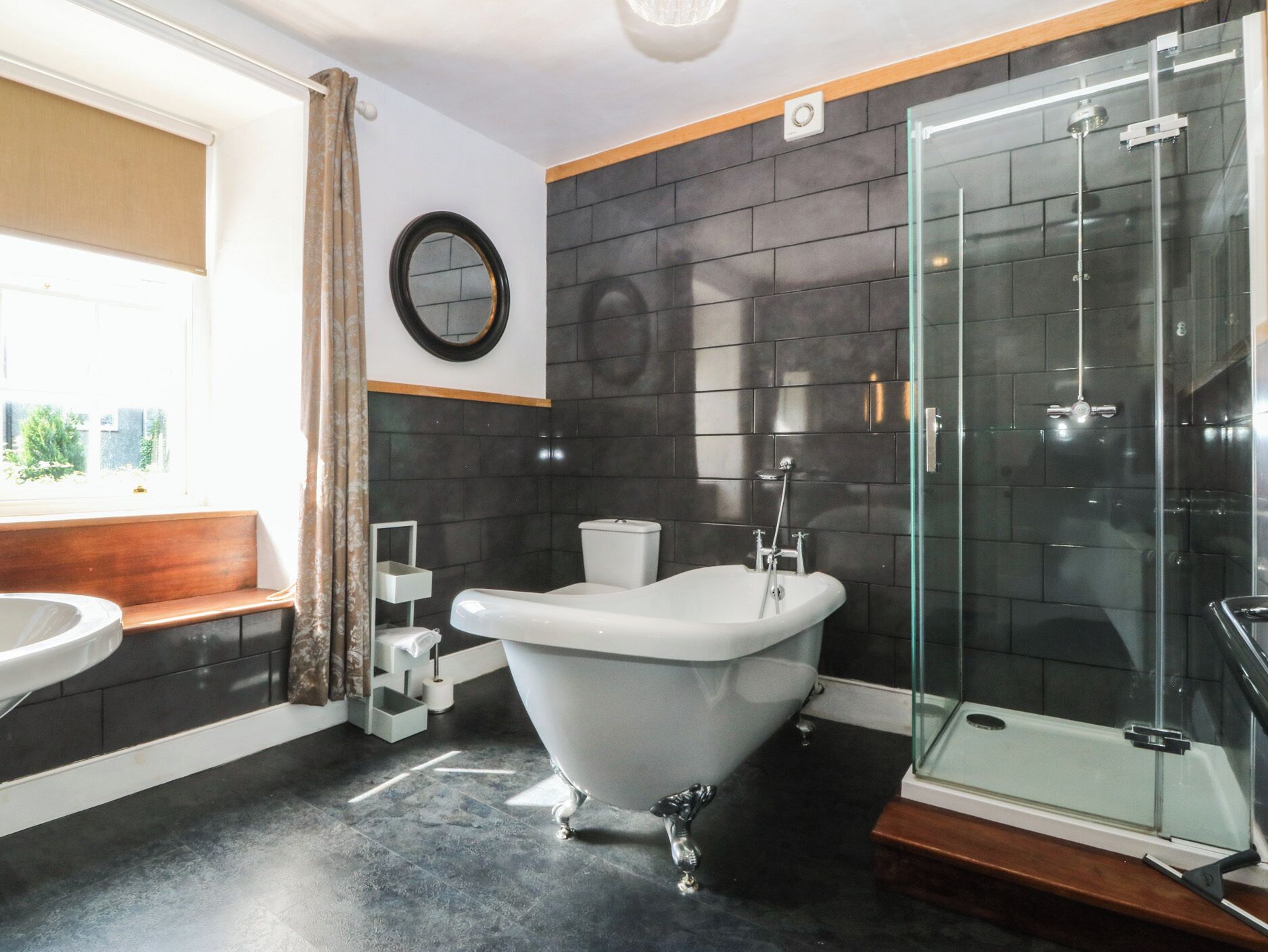 Un baño con bañera independiente, cabina de ducha de vidrio, inodoro y lavabo.