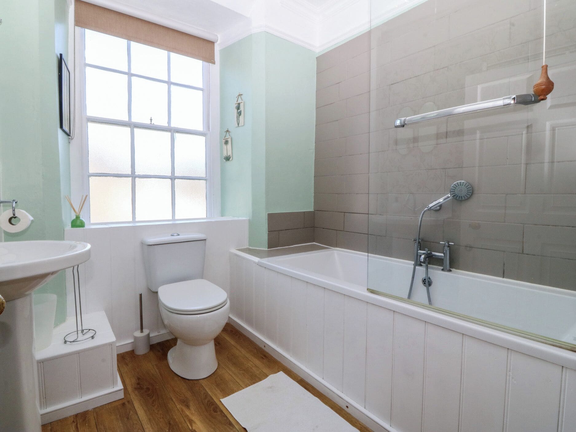Un baño con inodoro, lavamanos, bañera y ducha.