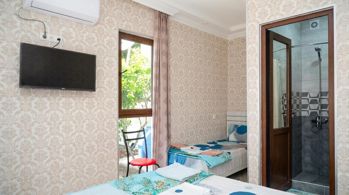 Une pièce comprenant un lit, une chaise, un téléviseur et un espace douche.