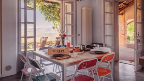 A dining area with a table set for breakfast, a view of the outdoors, and a sign reading 'SCARPA'. - Scarpa Villas (Piemonte)