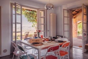 Un comedor con una mesa dispuesta para el desayuno, vistas al exterior y un cartel que dice 'SCARPA'.
