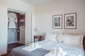 Una habitación de hotel con una cama, un armario y dos cuadros en la pared.