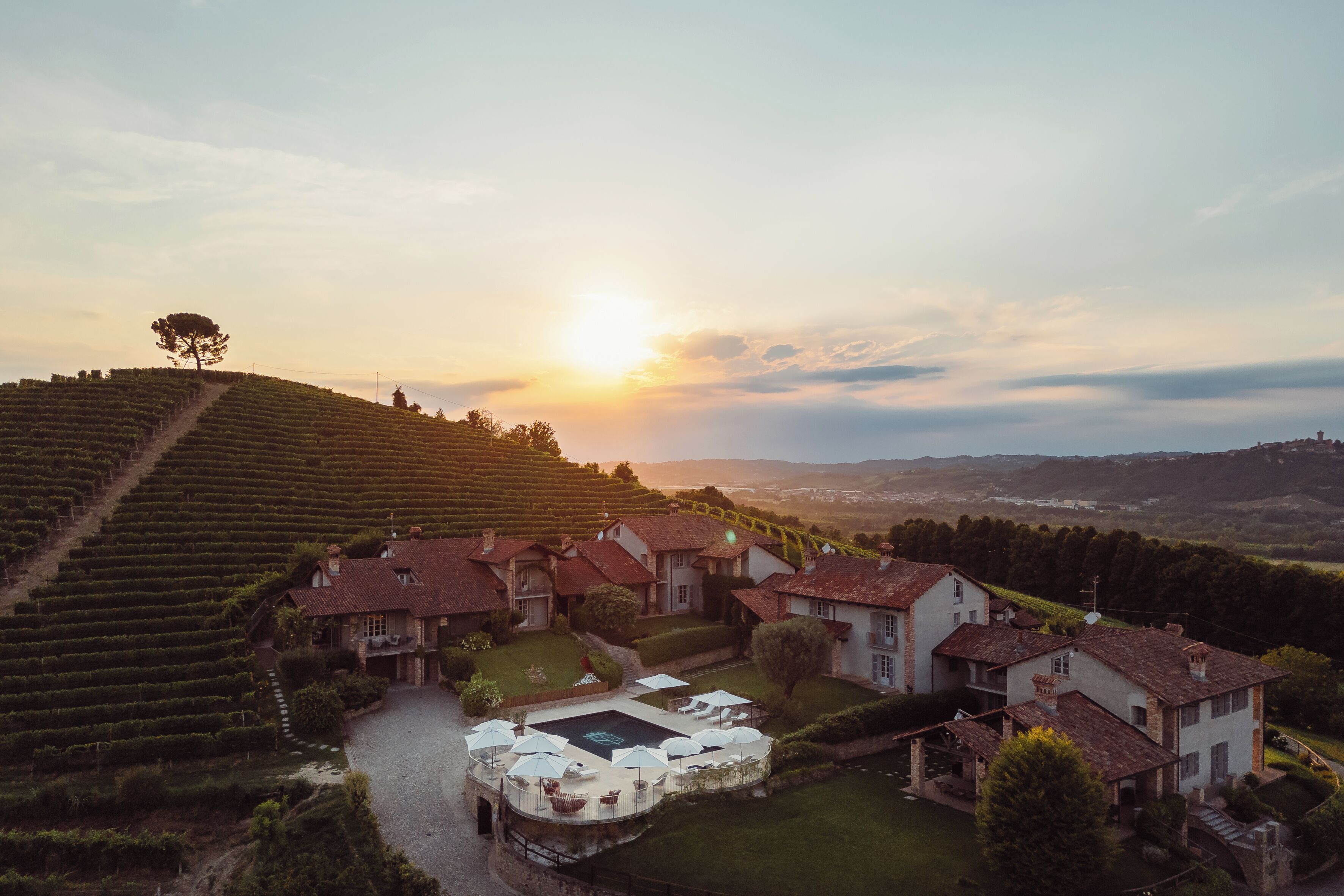 A vineyard estate with terraced fields, a central courtyard with outdoor seating, and traditional architecture.