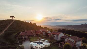 A vineyard estate with terraced fields, a central courtyard with outdoor seating, and traditional architecture.