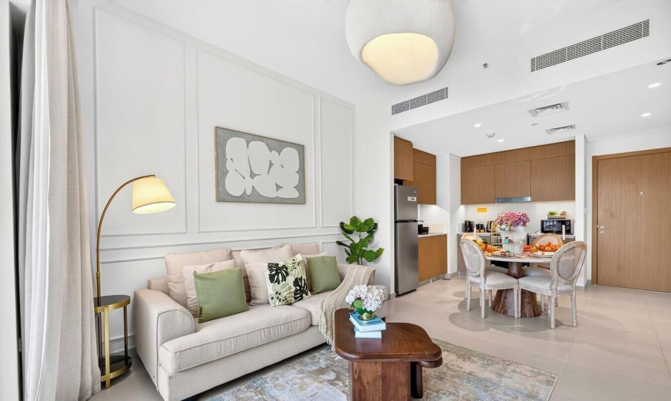 Un salon moderne comprenant un canapé, une table basse et un coin repas avec des chaises et une table.