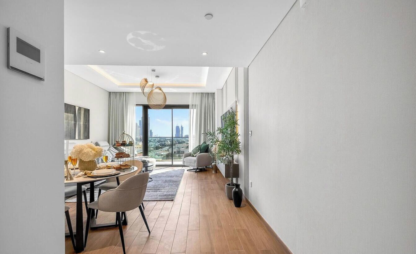Una sala de estar moderna con comedor, ventanas amplias y vista a la ciudad.