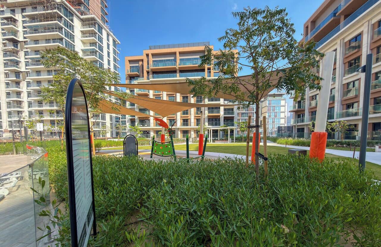 A modern residential complex with multiple high-rise buildings, a playground, and a well-maintained garden area.