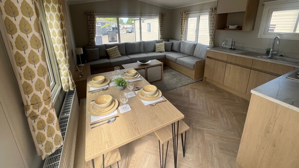 A modern RV interior with a dining area, kitchen, and living space. - Sleeps 8 - Skegness - Tv (Skegness)