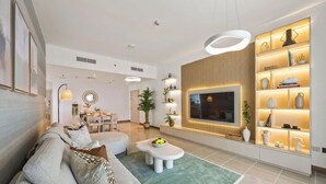 A modern living room with a sofa, coffee table, and a TV mounted on the wall. - Mediterranean Prestige 2BR | Sulafa Tower, Marina (Dubai)