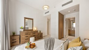 Ein modernes Schlafzimmer mit Bett, Nachttisch, Kommode und Spiegel.