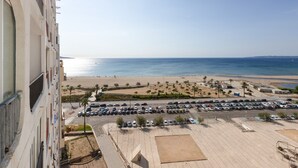Un hotel moderno con vista a la playa, un estacionamiento y una vista despejada del mar.