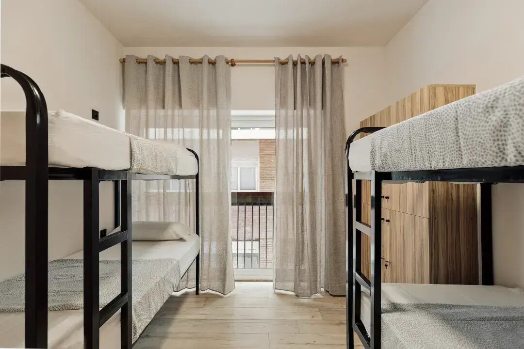 Un dormitorio con literas, un balcón y un armario de madera.