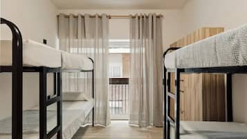 Un dormitorio con literas, un balcón y un armario de madera.