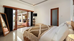 A spacious bedroom with a large bed, a sliding glass door leading to a balcony, and a modern design. - Villa Cinta Rose (Badung)