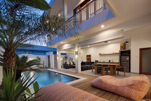 A modern house with a swimming pool, outdoor seating, and a kitchen area. - Villa Cinta Rose (Badung)