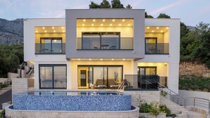 A modern two-story house with a swimming pool, outdoor seating, and a staircase leading to the upper level. - Villa LUX 55 Tucepi (Tučepi)