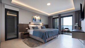 A modern bedroom with a bed, bedside table, artwork, and a view of the sea. - Villa LUX 55 Tucepi (Tučepi)