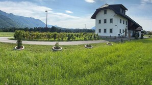 A white building with a sloped roof, surrounded by a grassy field and a vineyard. - Vacation Rental in Salzburg (Salzburg)