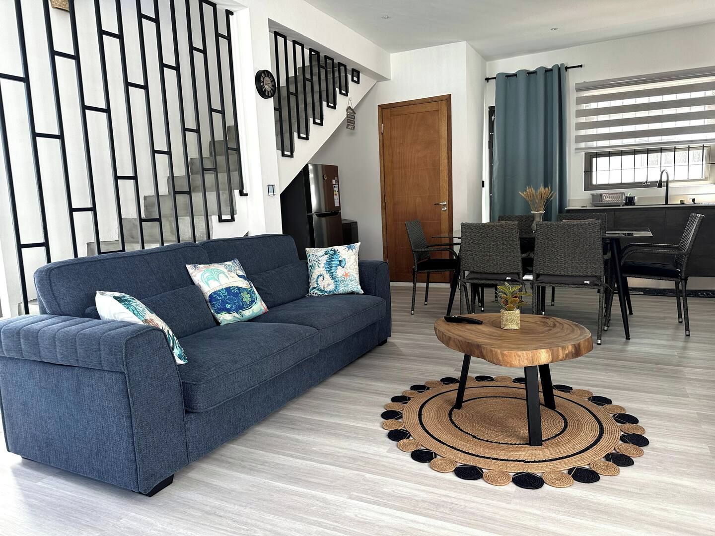 A modern living room with a sofa, a coffee table, and a staircase.