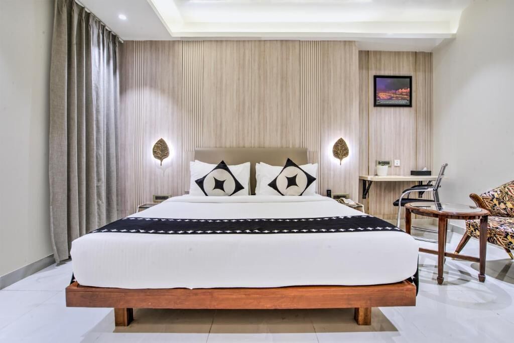 Una camera d'albergo moderna con un letto grande, una scrivania e una sedia.