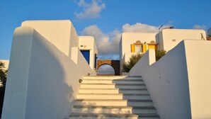 Un bâtiment blanc avec un escalier menant à une porte.