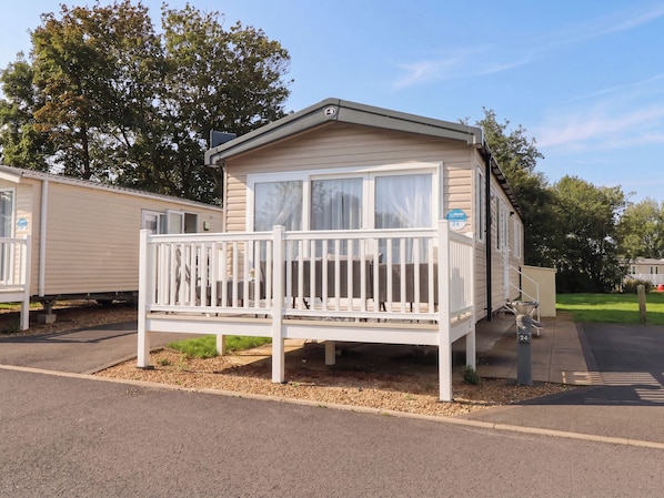A mobile home with a balcony, a window, and a door.
