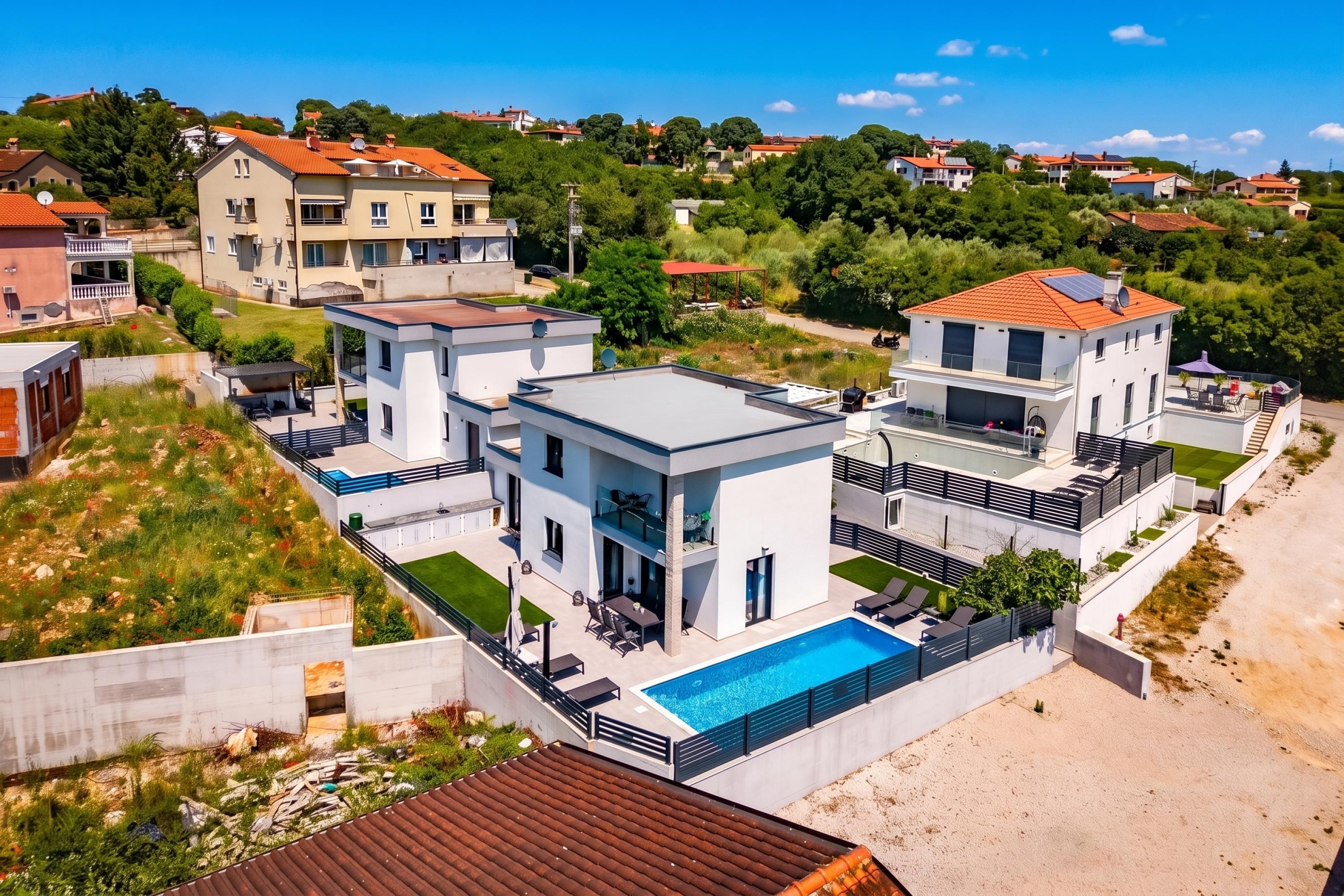 A modern two-story house with a swimming pool, large windows, and a balcony.