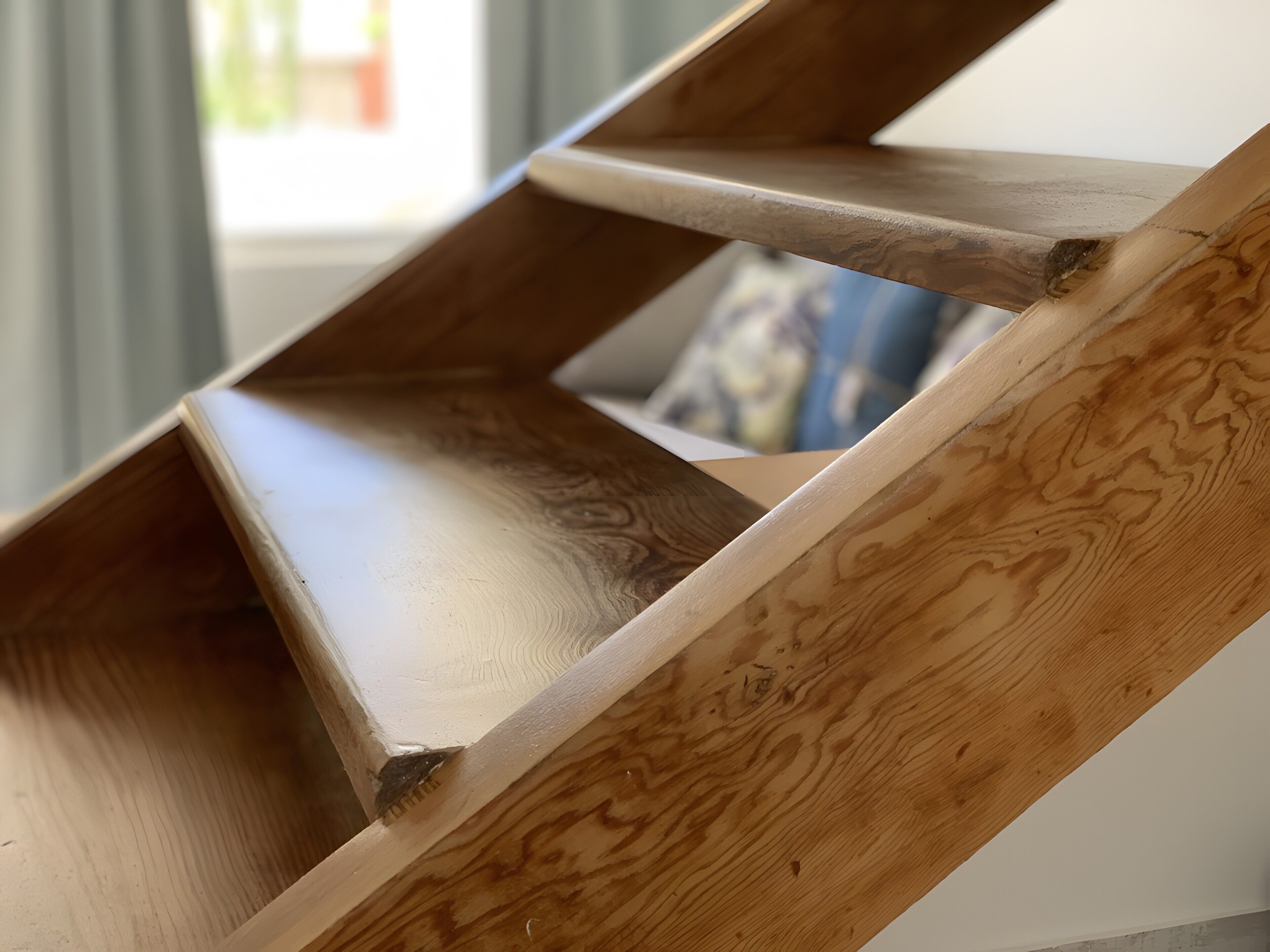 En trappe i træ med et unikt design, der fører op til en etage.